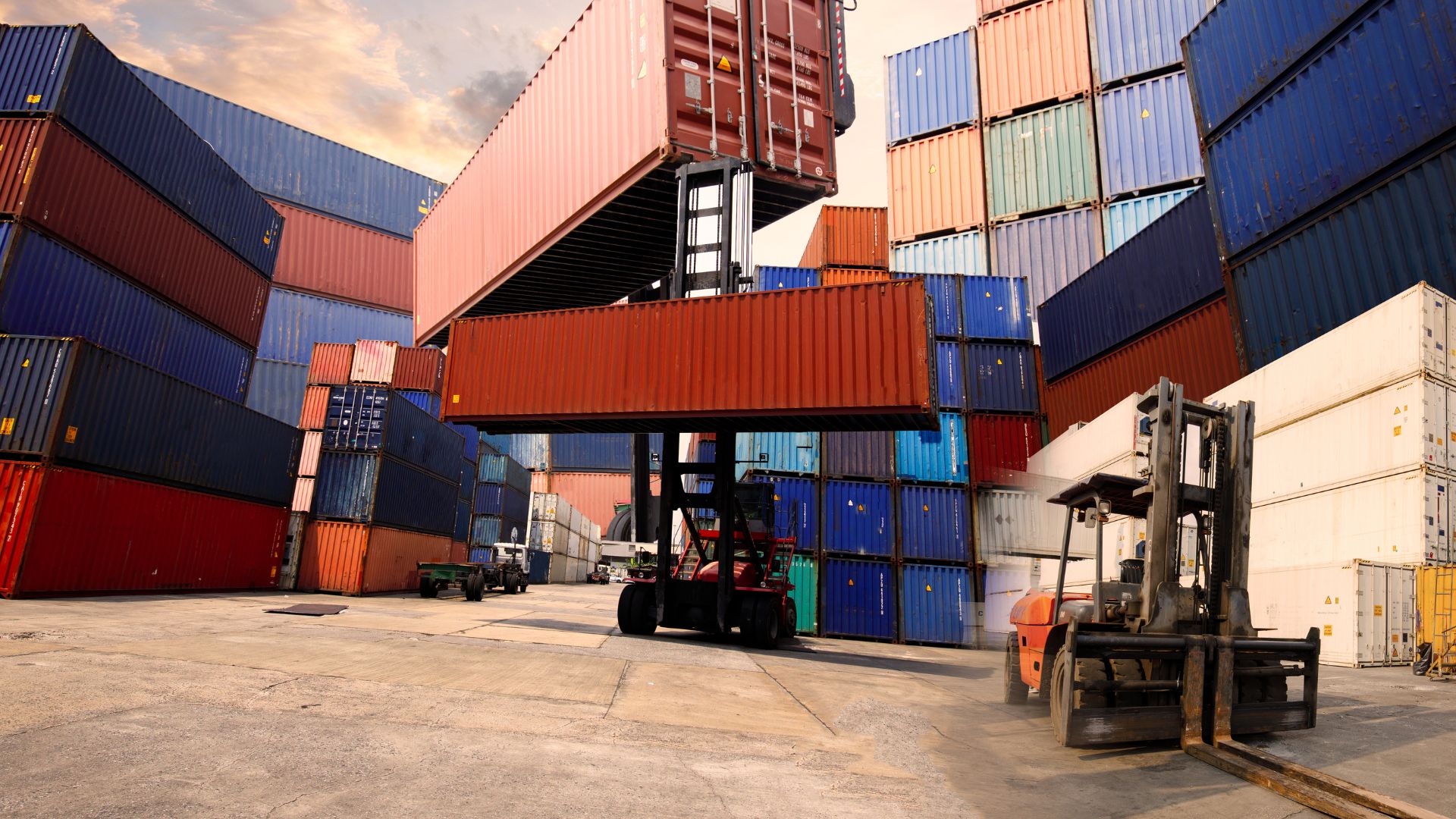 A forklift in front of a large stack of shipping containers