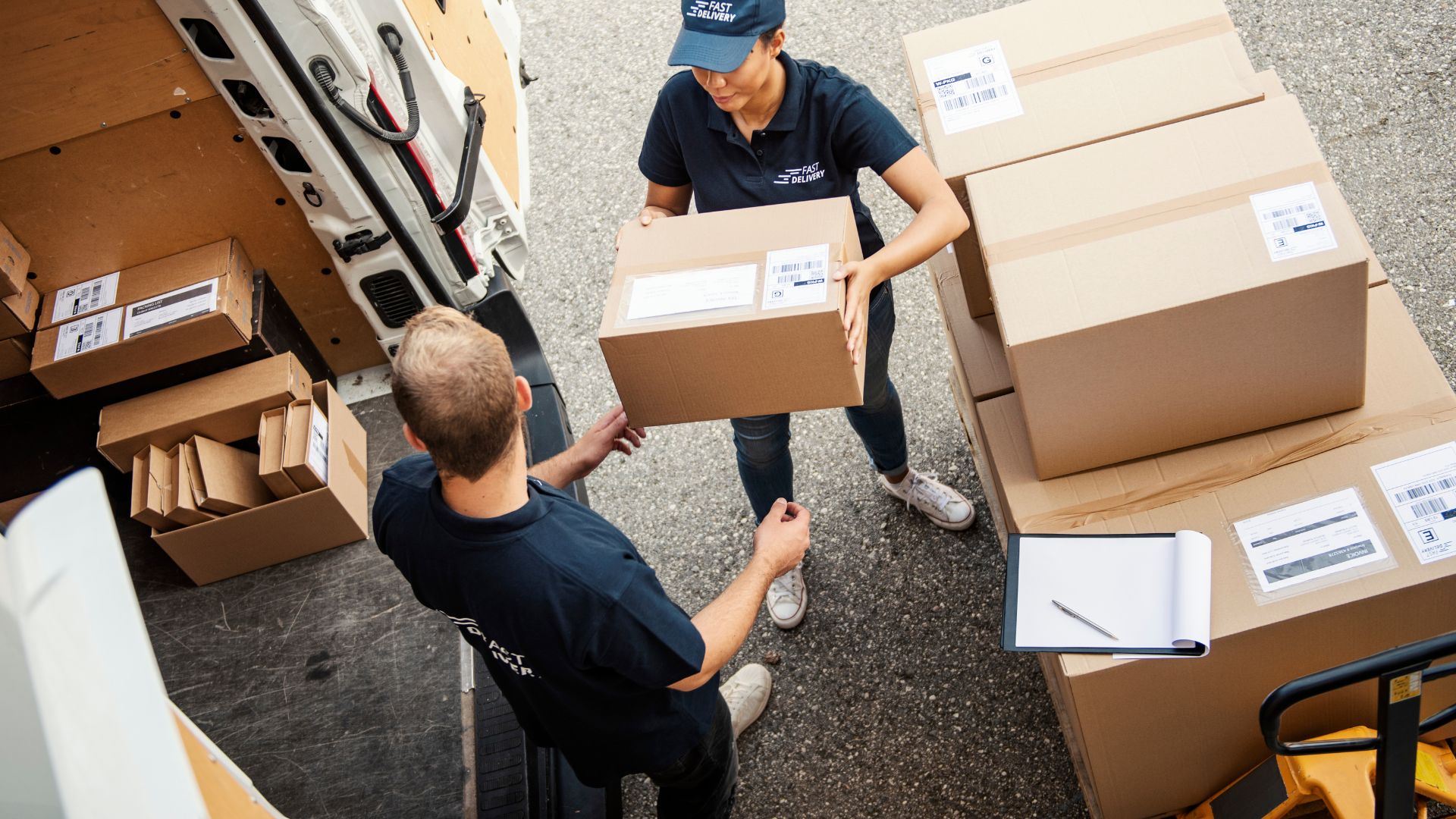 A couple of men standing next to each other near boxes